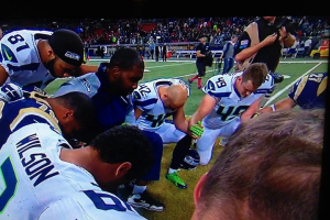 Seattle Seahawks players praying before a game.  <br/>