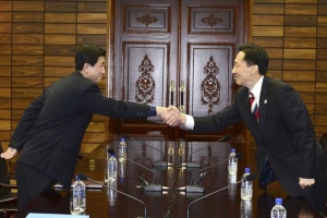 Head of the North Korean working-level delegation Park Yong-il (L) shakes hands with his South Korean counterpart Lee Duk-haeng during their talks at Tongilgak, a building on the northern side of the truce village of Panmunjom in the demilitarised zone separating the two Koreas, north of Seoul February 5, 2014. CREDIT: REUTERS/UNIFICATION MINISTRY/YONHAP<br />
 <br/>