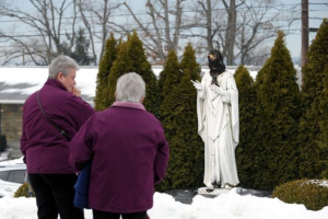 Spectators watched dismayed the now-disfigured statue of Jesus outside the church. <br/>Leigh Valley