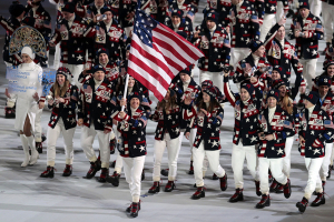 Todd Lodwick of the United States waves his national flag and enters the arena with teammates during the opening ceremony of the 2014 Winter Olympics in Sochi. (AP) <br/>