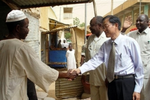 In this photo released by China's Xinhua News Agency, Liu Guijin , second right, Chinese special representative for African affairs, shakes hands with a local man at a market in al-Fashir, Sudan Tuesday, May 22, 2007. <br/>