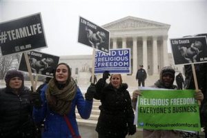 Demonstrators participate in a rally in front of the Supreme Court in Washington, Tuesday, March 25, 2014, as the court heard oral arguments in the challenges of President Barack Obama's health care law requirement that businesses provide their female employees with health insurance that includes access to contraceptives. Supreme Court justices are weighing whether corporations have religious rights that exempt them from part of the new health care law that requires coverage of birth control for employees at no extra charge. (AP Photo/Charles Dharapak) <br/>