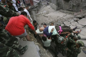 Rescuers carry an injured man out of the debris of collapsed buildings after the earthquake in Beichuan county in southwest China's Sichuan province, Tuesday, May 13, 2008. Rescue workers sifted through tangled debris of toppled schools and homes Tuesday for thousands of victims buried or missing after China's worst earthquake in three decades, where the death toll soared to more than 12,000 people in the hardest-hit province alone. <br/>(Photo: AP Images / Wang Jiaowen, ColorChina) 