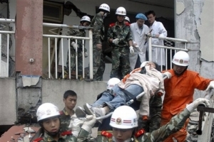 In this photo released by China's Xinhua News Agency, firemen carry a student who was buried at a school building, in Beichuan County, northeast of the epicenter, southwest China's Sichuan Province, Tuesday, May 13, 2008. Rescuers pushed further into remote villages flattened by China's devastating earthquake, finding one with nearly 80 percent of its population killed during searches Wednesday certain to dramatically raise the official death toll of 12,000. <br/>(Photo: AP Images / Xinhua, Chen Faliang) 