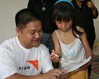 Li Yao (9) shares her story with a World Vision staff member in Sichuan province. <br/>(World Vision) 
