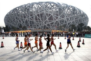 In this April 18, 2008 file photo, athletes walk past the Olympic National Stadium 'Bird Nest' during the Race Walking Challenge in Beijing, China. In a move unprecedented for the Olympics, tickets for the opening and closing ceremonies are embedded with a microchip containing the bearer's photograph, passport details, addresses, e-mail and telephone numbers. The intent is to keep potential troublemakers from the 91,000-seat National Stadium as billions watch on TV screens around the world. <br/>(Photo: AP Images / Andy Wong, File) 