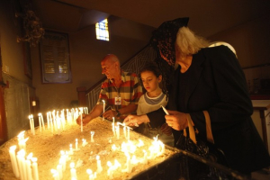 Christians light candles at the Armenian Church in Baghdad during an Easter service in 2012, when threats of violence were already a daily facet of their lives. (Reuters) <br/>