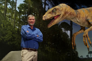 Ken Ham, founder of the Creation Museum, stands in front of one of the dinosaur exhibits. The museum opens May 28. <br/>