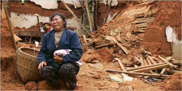 Li Fucui, 47, cries in front of the debris of her collapsed house, which buried her brother-in-law, in Huili County, Sichuan Province <br/>Reuters