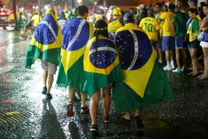 Brazil soccer fans walk in the rain after watching a broadcast of their team's loss against Germany in their 2014 World Cup semi-final match, in Rio de Janeiro July 8, 2014. Reuters/Jorge Silva <br/>