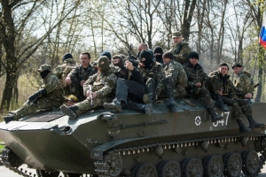 A pro-Russian gunman clears the way for a combat vehicle with gunmen on top in Slovyansk, Ukraine,  <br/>www.ctvnews.ca