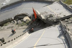 People ride motorbicycles past a collapsed bridge in one of the worst earthquake-hit areas of Yingxiu town <br/>