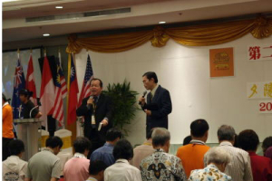 Dr. John Ong, on the left, delivering a message on the last night of the retreat. <br/>(CCCOWE)