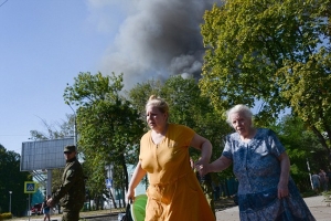 Women rush across the street after the shelling of a town in Donetsk, eastern Ukraine. <br/>