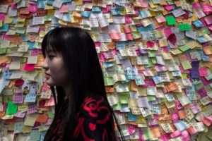 A woman walks past a wall of messages of support near an occupied area of Hong Kong, 7 October 2014. (Getty Images) <br/>