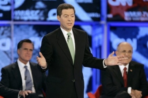 Republican presidential hopeful Sen. Sam Brownback, R-Kan. answers a question between former Massachusetts Gov. Mitt Romney, left, and former New York City Mayor Rudy Giuliani, right during the Republican presidential primary debate hosted by Saint Anselm College in Manchester, N.H., Tuesday, June 5, 2007. <br/>