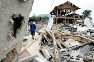 A Chinese villager walks past collapsed houses after a strong earthquake hit the Xiahexia village in Pu'er, southwestern China's Yunnan province on Tuesday, June 5 2007. Tens of thousands of earthquake victims in southwest China were living in tents or in the open Monday, fearful of returning to their damaged homes a day after a magnitude 6.4 quake killed three and injured at least 300. <br/>(AP Photo/Color China Photo) 