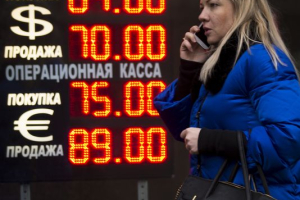Signs advertising the ruble's exchange rate light next to the exchange office in Moscow on Dec. 16, 2014. (Photo: Alexander Zemlianichenko, AP) <br/>