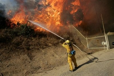 Nick Carone of the San Bernardino County Fire Department Grand Terrace unit fights a wildfire in Chino Hills, Calif., Sunday, Nov. 16, 2008. Calmer wind Sunday aided firefighters battling wildfires that have destroyed hundreds of homes in Southern California, forced thousands of residents to flee and blanketed much of the region with choking smoke. <br/>(Photo: AP/Marcio Jose Sanchez)