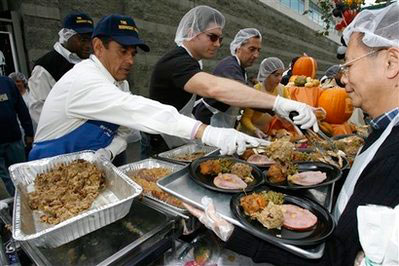 Los Angeles Mayor Antonio Villaraigosa, left, helps serve Thanksgiving meals at the Fred Jordan Mission for some 2,000 needy men, women and families, Thursday Nov. 27, 2008, in Los Angeles. <br/>(Photo: AP Images / Damian Dovarganes)