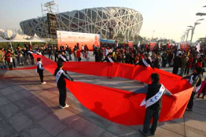 Volunteers form a red ribbon during a World AIDS Day event at the Olympic Green next to the Bird Nest in Beijing, capital of China Nov. 30, 2008 <br/>(Reuters)