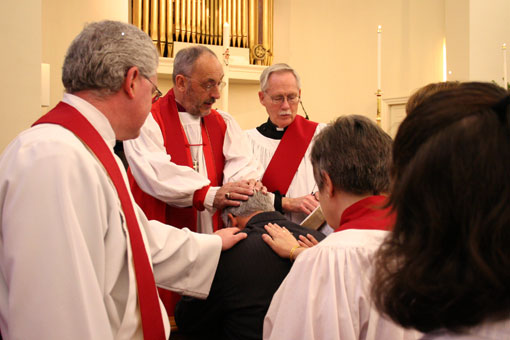 The Rt. Rev. Martyn Minns (second from left), missionary bishop of Convocation of Anglicans in North America, prays for a congregant at Truro Church in Fairfax, Va., on Sunday, Nov. 30, 2008. <br/>(Photo: The Christian Post)