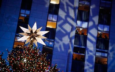 People look on from office windows as the Rockefeller Center Christmas tree stands lit during the 76th annual lighting ceremony Wednesday, Dec. 3, 2008, in New York. <br/>(Photo: AP Images / Jason DeCrow)
