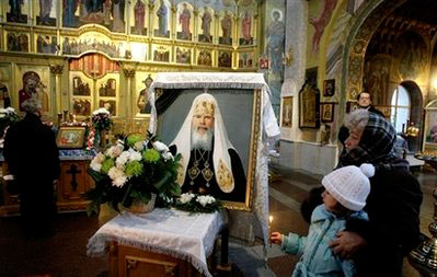 Orthodox believers look at a portrait of late Russian Orthodox Patriarch Alexy II during a service at St. George cathedral, Moscow, Saturday, Dec. 6, 2008. Alexy, who died Friday at age 79, led the church for 18 years, from the last year of the officially atheistic Soviet Union through a massive revival that saw it become the world's largest Orthodox church. <br/>(Photo: AP Images / Mikhail Metzel)