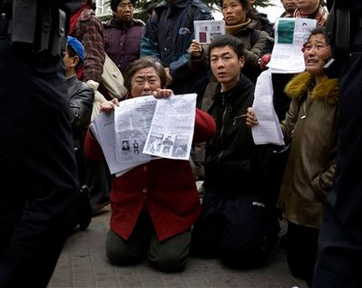 Chinese petitioners kneel among police officers while holding letters detailing their complaints they asked for justice and human rights during a protest outside the Foreign Ministry building in Beijing, Wednesday, Dec. 10, 2008. Two dozen people held a bold protest outside China's Foreign Ministry, using the 60th anniversary of the declaration of human rights to decry a myriad of alleged government abuses. <br/>(Photo: AP Images / Andy Wong)