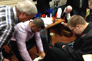 Tim Tebow shines the shoes of a Night to Shine prom attendee. Tim Tebow Foundation <br/>