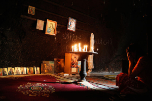 A woman prays inside a damaged church in Maaloula August 21, 2014. Residents of Maaloula, a Christian town in Syria, call on other Christian groups and minorities to stand up to the radicalism that is sweeping across Syria and Iraq. The town was regained by Syrian Army forces in April from Islamic militants, and several months later life is slowly returning to the town. REUTERS/Omar Sanadiki <br/>