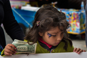 A child buys tickets at the Halloween-Día de los Muertos fundraiser for Junipero Serra Elementary in Bernal Heights. The event netted $3,000 for the PTA. Photo by Tearsa Joy Hammock / San Francisco Public Press. <br/>