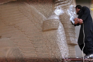 An Islamic State group militant is shown destroying a statue of an Assyrian diety in the Iraqi Governorate of Nineveh, in this image grab from a video released by Welayat Nineveh Media Office on February 26, 2015 (AFP Photo/) <br/>