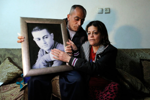 The mother and father of Muhammad Musallam, an Israeli Arab held by Islamic State in Syria as an alleged spy, react with a picture of him in their East Jerusalem home March 10, 2015. A video posted online by Islamic State militants on Tuesday showed a child killing Muhammad Musallam, an Israeli Arab accused by the group of being a Mossad spy, with a bullet to the head. REUTERS/Ammar Awad  <br/>
