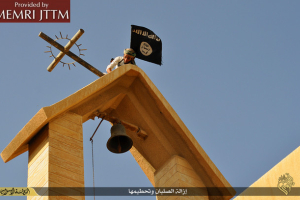 A Christian cross falls to the ground as a member of the Islamic State terror group erects a black flag in its place atop St. George monastery in northern Iraq. Photo: MEMRI JTTM <br/>
